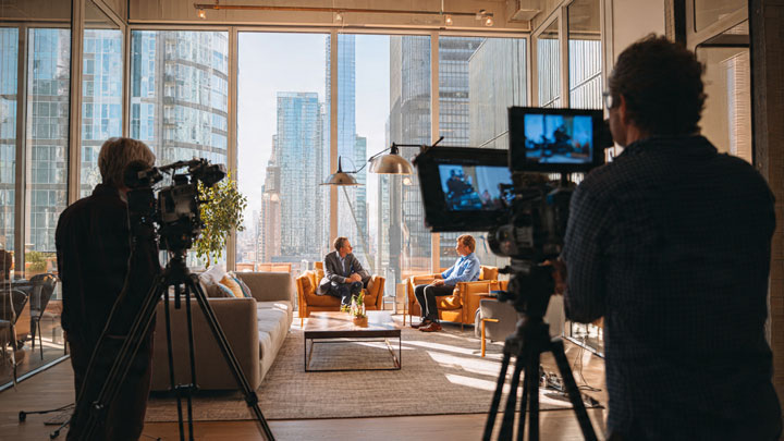 A professional video production team filming a corporate scene in a modern Johannesburg office.